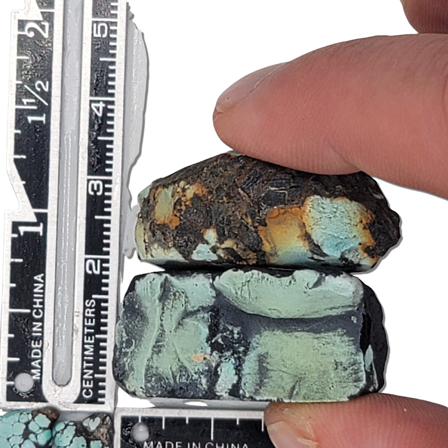 A 27-gram pair of natural turquoise stones with vibrant greenish-blue hues and striking black matrix. Ideal for creating unique jewelry or as a raw collectible, available at www.naturalturquoise.com.