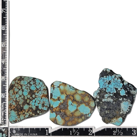 A natural turquoise stone triplet weighing 21 grams, featuring vibrant blue tones with golden accents and bold dark matrix patterns. The stones measure approximately 4 cm x 3 cm, 3.8 cm x 2.8 cm, and 3.7 cm x 2.5 cm, displayed with a ruler for scale. Available for purchase at www.naturalturquoise.com, ideal for lapidary and jewelry projects.