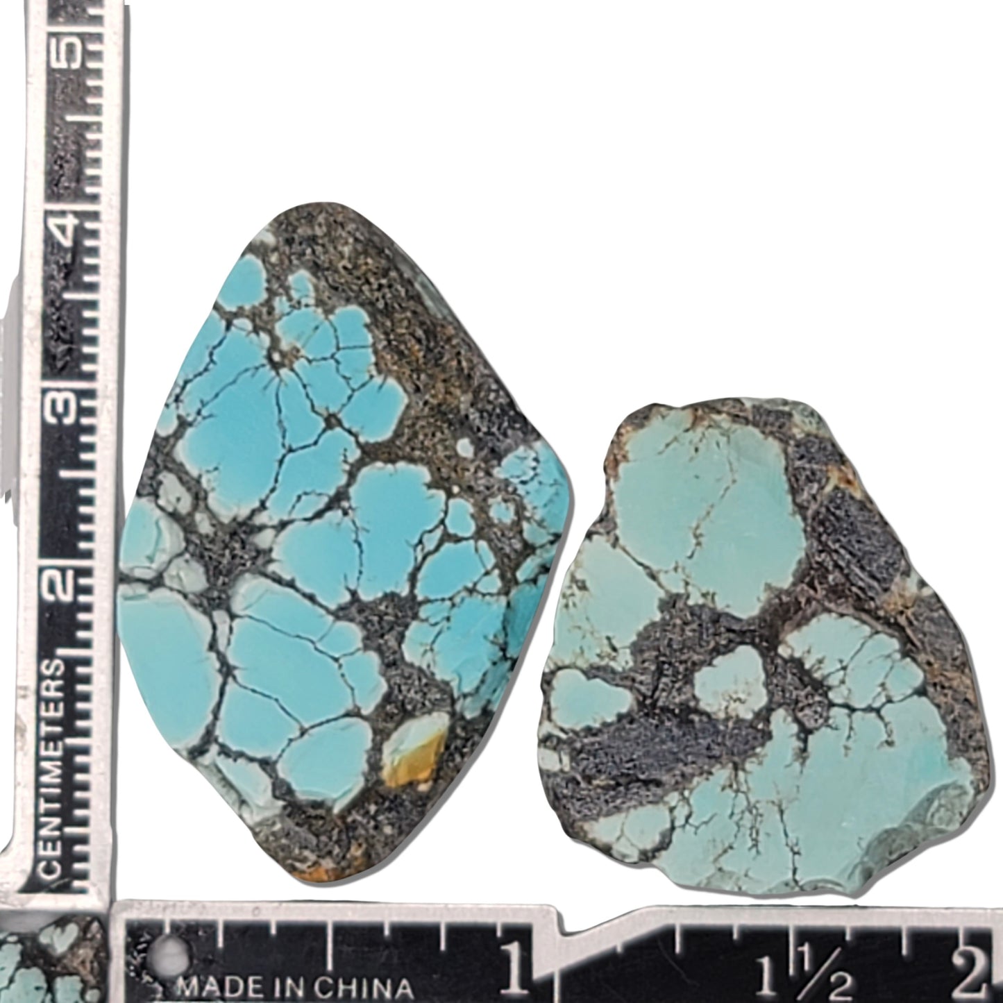 A pair of natural turquoise rough stones weighing 19 grams, featuring vibrant sky-blue tones with black and white matrix patterns. The largest stone measures approximately 3.7 cm x 2.5 cm x 0.7 cm. Ideal for jewelry making or lapidary projects, available at www.naturalturquoise.com.