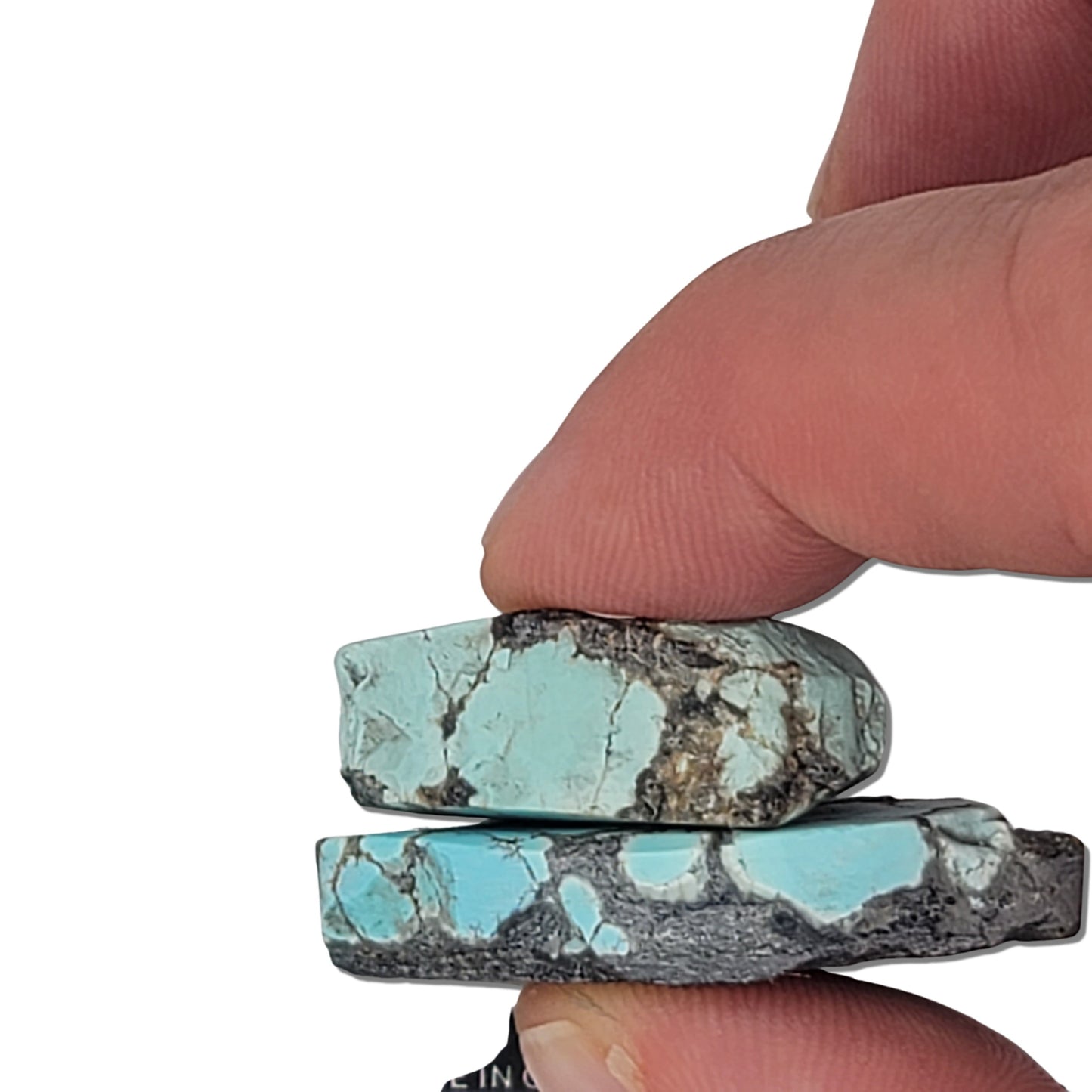 A pair of natural turquoise rough stones weighing 19 grams, featuring vibrant sky-blue tones with black and white matrix patterns. The largest stone measures approximately 3.7 cm x 2.5 cm x 0.7 cm. Ideal for jewelry making or lapidary projects, available at www.naturalturquoise.com.